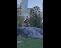 Guy talks and sing wear green shirt with cape at park 