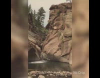 Guy jumps from very tall cliff into waterfall pool