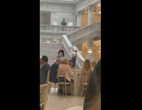 Woman in black dress sits on the stairs