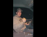 Guy chewing tobacco brown sweater car 