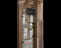 Electrician guy shows off how he ran wires inside of open wall 