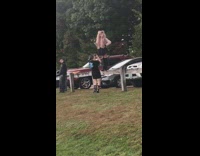 Woman cosplay pink wig stand fence parking lot