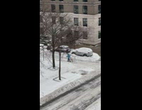 Person in light blue snow jacket cross country skiing on the road 
