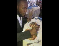 Guy eats two plates of food at banquet