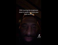 Guy looking at phone lowers brightness