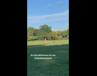 Guy waves pink yellow ribbons flags park 