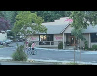 Guy red shirt ride bike small jump outside store