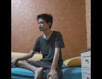 Guy sits on bed alone and cries orange wall blue bed