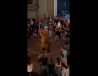 Dinosaur couple dance in the middle of crowd