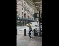 Guy plays trombone on sidewalk 