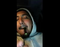 Guy smokes weed in car, lights up pipe, spits pip out and coughs