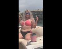Black pink bikini girl adjusts boobs boat
