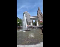 Man shirtless sits and bathes on the water fountain