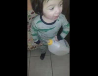 Toddler drinks from milk galloon and nipple 