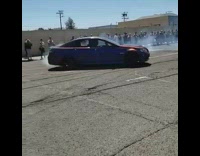 Car and motorcycle do donuts in parking lot 
