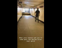 Guy walks through subway tunnel with stick