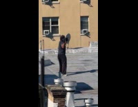 Collab WINY - Man wears weight gloves exercises on rooftop