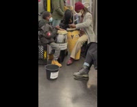 Boy and lady play drums on subway 