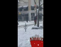 Guy cross country skiing on the sidewalk