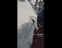 Guy pats snow with a small shovel 