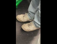 Person wear worn out white shoes subway