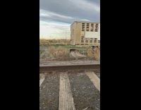 Woman in leather jacket and bra poses on the railroad