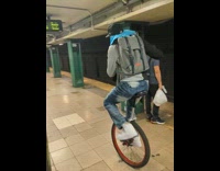 Guy rides on unicycle at subway station 