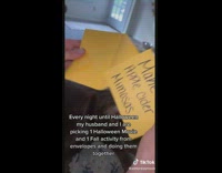 Couple pick envelopes with halloween movies and fall activities 