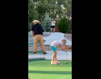 Blue shirt girl runs jumps mini golf 