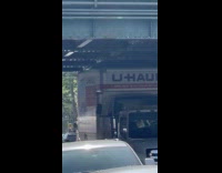 Truck carry U Haul truck pass under bridge