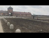 Girls take photos outside concentration camp 