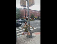 Woman hanging onto traffic light by hair spinning around 