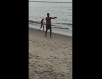 Guy moves arms side to side beach 