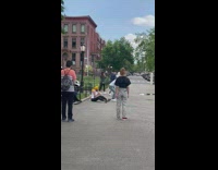 Guy dance while friend play flute park