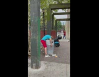 Guy passed out on trash can outside