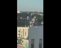 Guy paints building white rooftop roller dish 