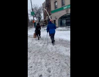 Guy walking on crosswalk holding ski gear
