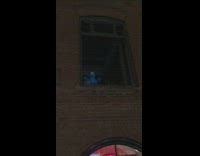 Cookie Monster stuffed toy stands on window sill with arms out
