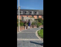 Two women wears coat and hat sits at the park