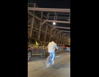 Man riding citibike on brigde 
