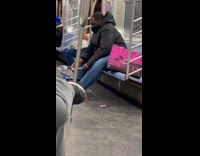 Guy playing on a tiny drumset on the subway train floor