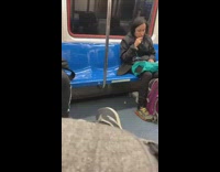 Black jacket girl brushes teeth subway earphones 