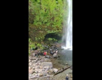 Girl sits on rock picture waterfall