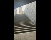 Woman balances and rides the unicycle down the stairs