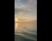 Man Stands Still on Beach as he Take Pictures