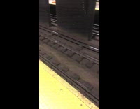 MTA workers in orange vests clean subway train tracks