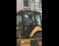 Balloon human sits inside bulldozer 