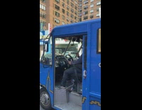 Guy playing drums on steering wheel with drumsticks