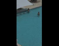 Woman in bikini sit on the pool near the beach