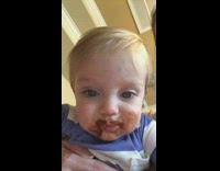 Baby boy with messy face after eating chocolates